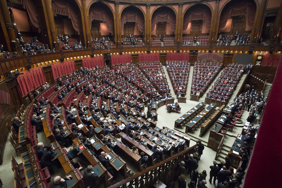 Empty legislative chamber with rows of desks before a session — public institutions and democratic process behind political news
